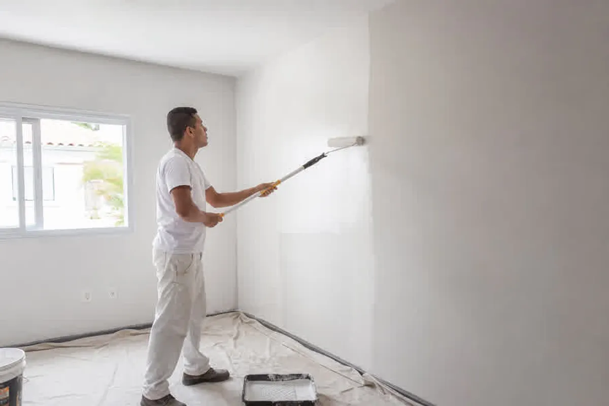 Pintor aplicando tinta em parede interna de residencia no Pantano do Sul